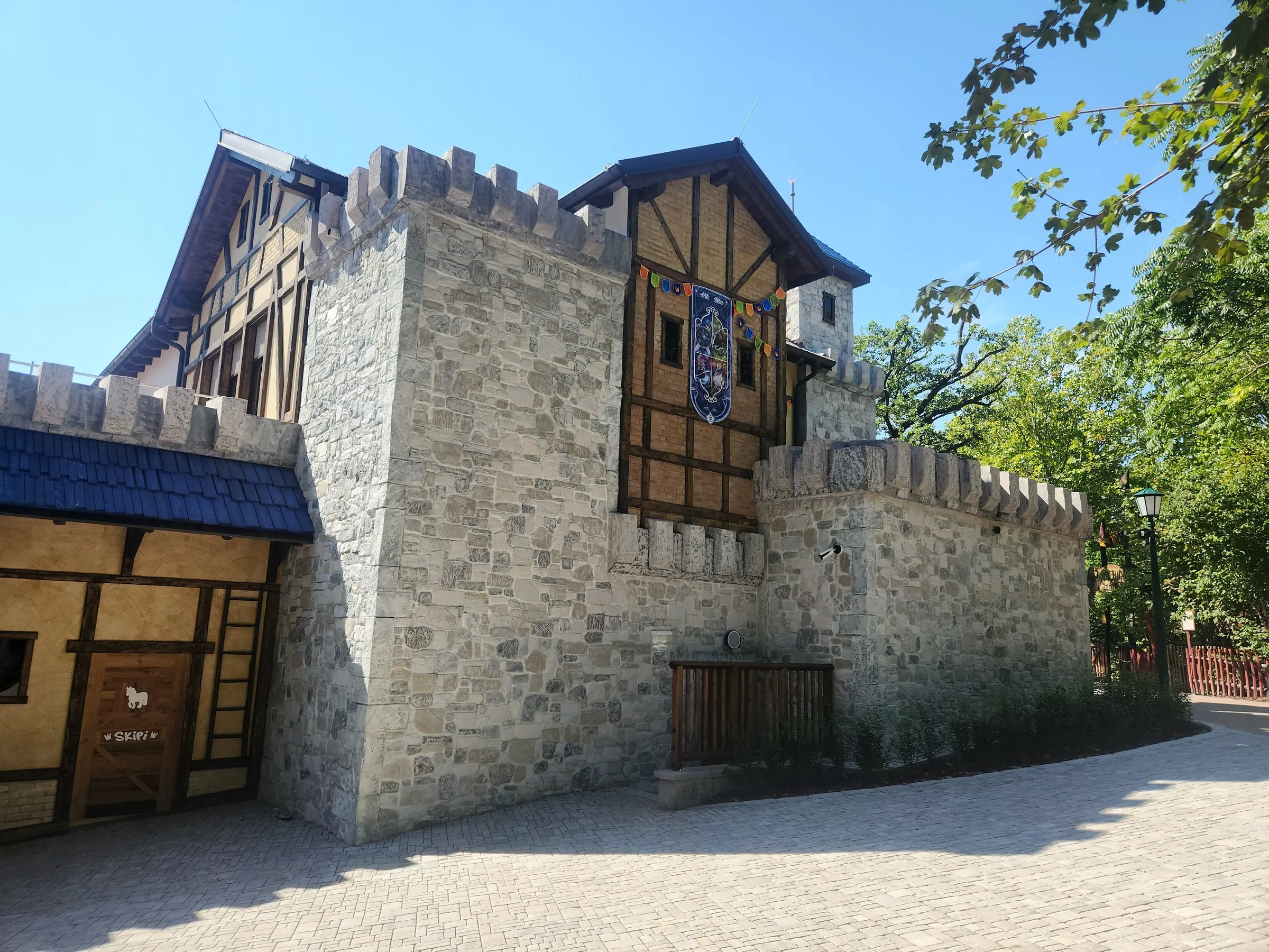 Seitenansicht der Burgwelt mit Bruchsteinmauer, Zinnen und Fachwerk
