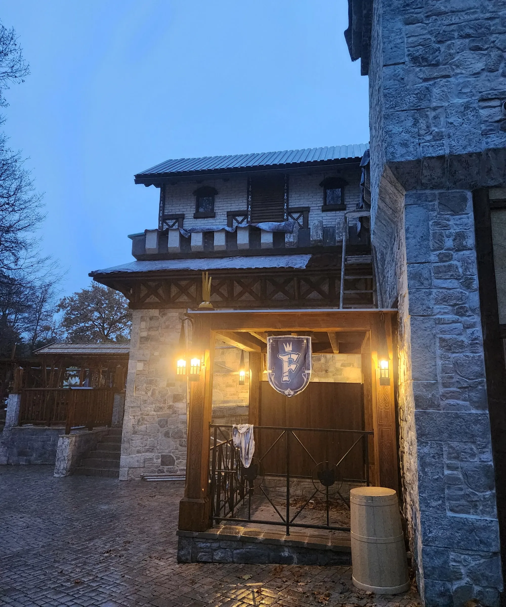 Mittelalterliche Taverne aus Bruchstein mit Turm, Holzfenstern und Wimpeln