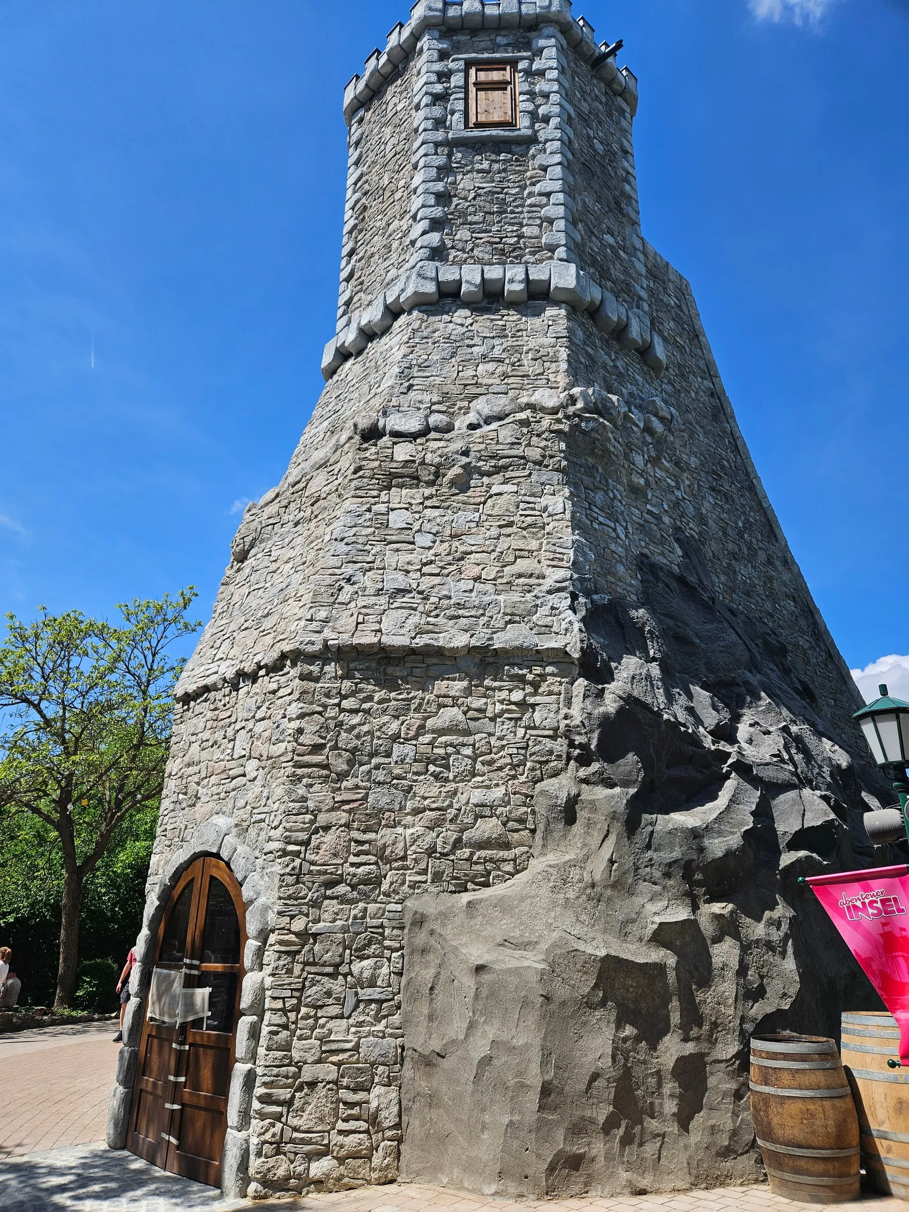 Hoher mittelalterlicher Steinturm auf modellierter Felsbasis mit Holztür